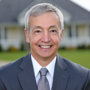 Smiling man in a suit outdoors.