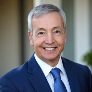 Smiling gray-haired businessman headshot in blue suit